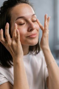 Woman putting on serum for skincare. 