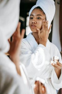 Woman putting on vitamin C for skincare. 