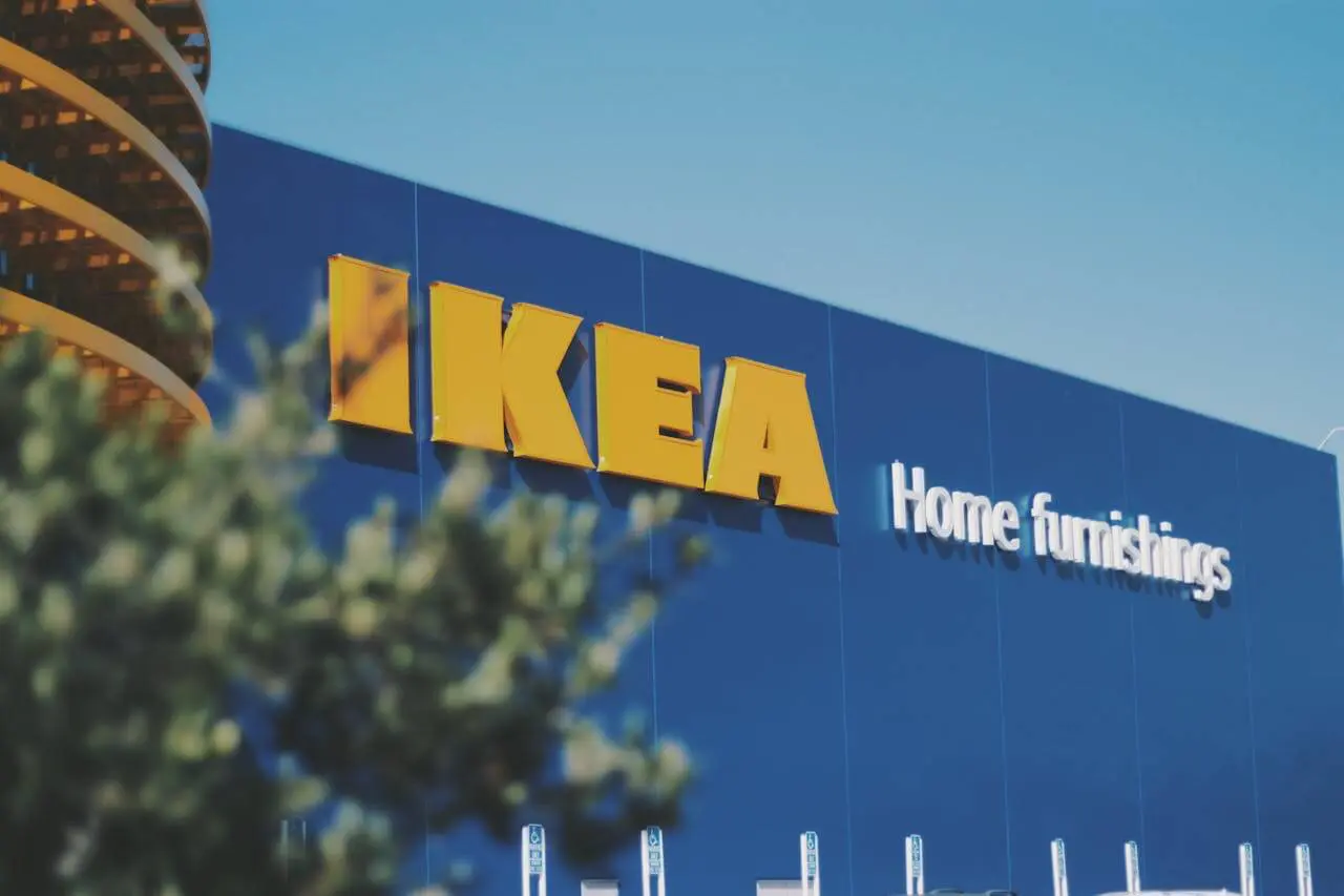 Photo of an IKEA store exterior with the large yellow IKEA logo and blue building, representing affordable home furnishing options for first apartments.