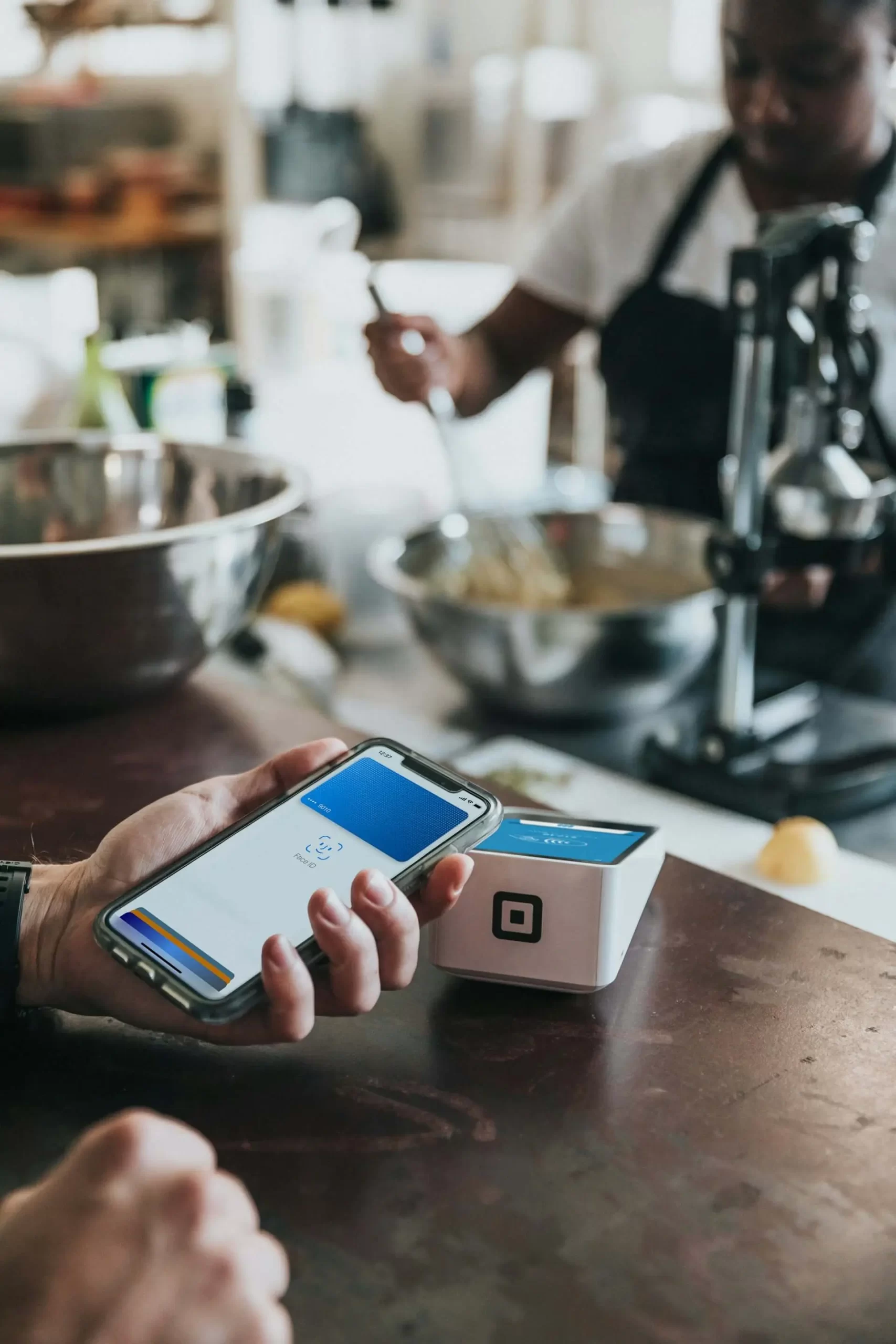 Young adult making a mobile payment with a no-fee bank account debit card.