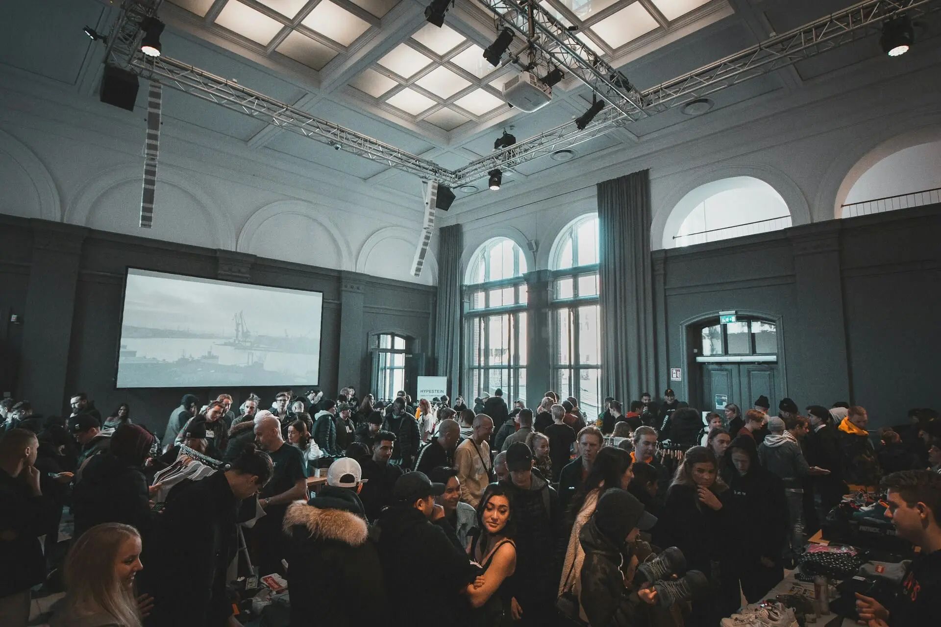 Young professionals networking at a conference-style event with drinks and conversations.